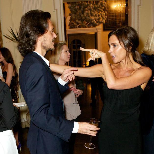 A woman and man face each other, the woman points two horizontal fingers at him