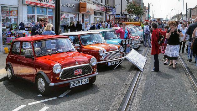 Visitors surround an exhibit of classic Minis 