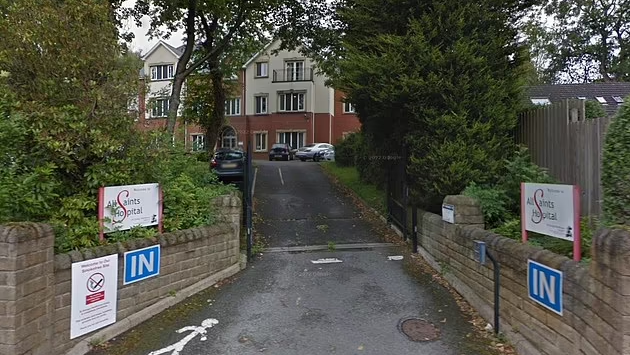 A Google streetview image of the entrance and driveway into All Saints Hospital in Oldham.