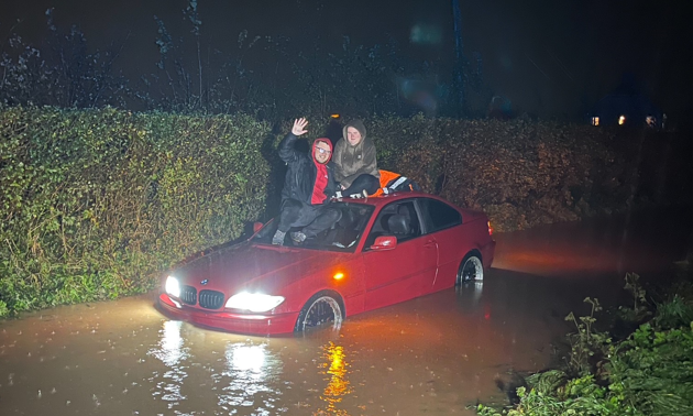 Ashley and her partner Davie are sat on the roof of their car whilst stranded in the floods near Taunton. 