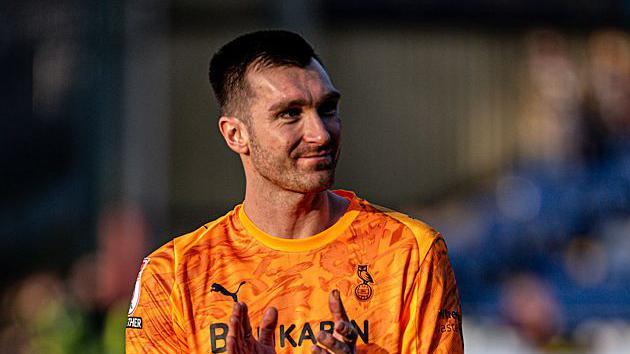 Oldham Athletic goalkeeper Mathew Hudson applauding the fans after his side's victory against Harrogate Town.