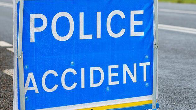 Police accident sign on a road, with bold white letters saying POLICE ACCIDENT on a blue background.