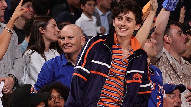 Actor Timothee Chalamet stands up courtside during the New York Knicks v Boston Celtics game