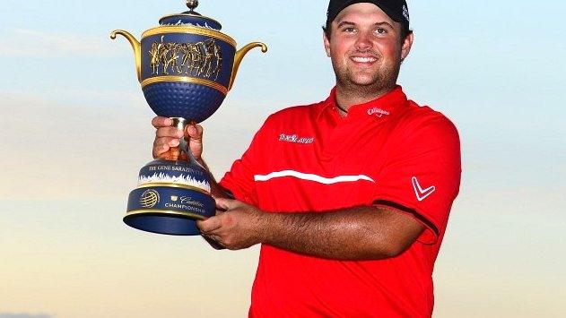 Patrick Reed holds aloft the WGC-Cadillac Championship trophy