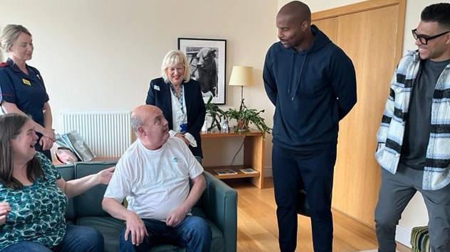 Osi Umenyiora and Jason Bell surprising a hospital patient