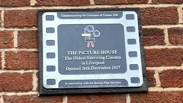 Plaque awarded by the British Film Institute which reads: Commemorating the Centenary of Cinema 1996. The Picture House. The Oldest surviving cinema in Liverpool. Opened 26th December 1927. In association with the British Film Institute.