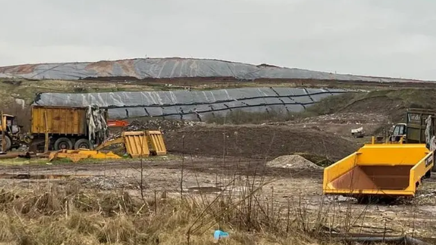A landfill site in the middle of a grassy area