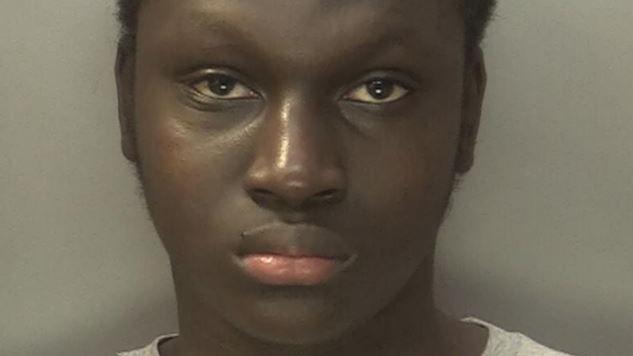 Oumar is staring at the camera and has short, dark hair and a grey top on.
