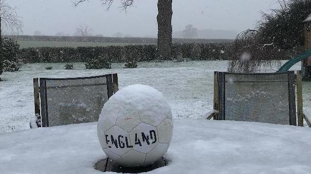 A football on a snowy garden table