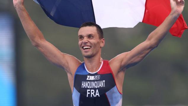 Para-triathlete Alexis Hanquinquant celebrates with the French flag