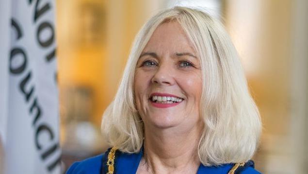 Jo Gilford with long blonde hair wearing a blue top