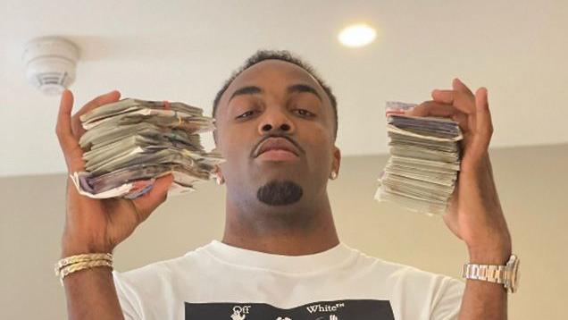 Davante James holds wads of banknotes in each hand