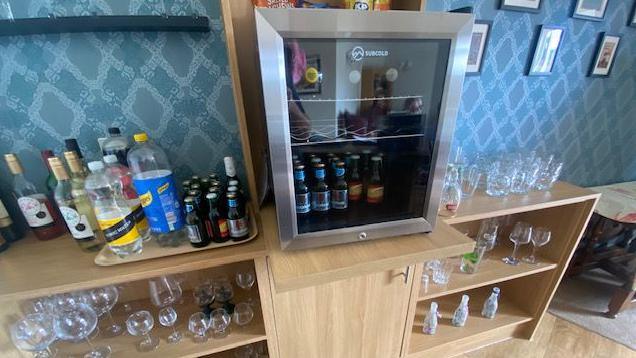 A fridge and cabinet of drinks for the pub