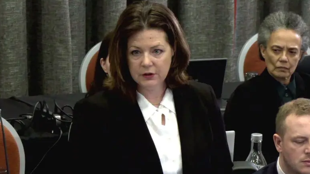 Brenda Campbell KC has shoulder length brown hair and is wearing a white shirt and black blazer. She is speaking in the picture.