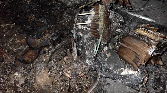 The burnt remains of an e-bike, including a wheel with its spokes visible. 