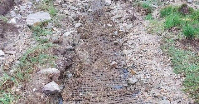 An eroded section of the pathway, showing matting underneat the rocks