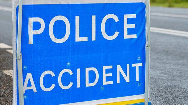 'Police Accident' blue and white sign on a road.