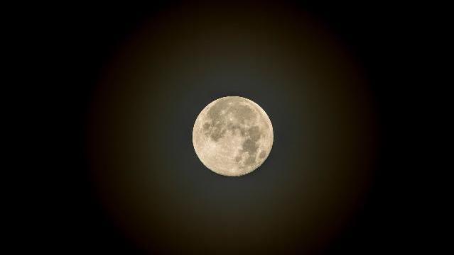 A large yellowish moon against a black background