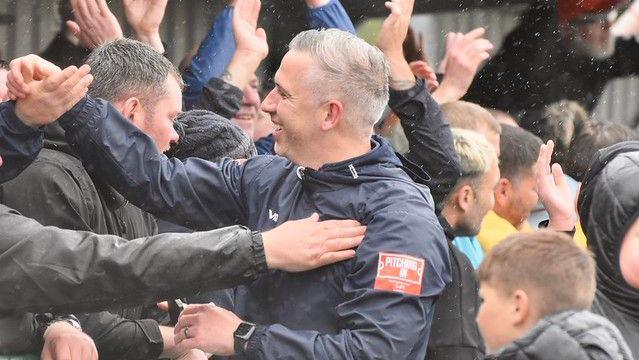 Merthyr Town manager Paul Michael celebrating with supporters after a game against Sholing United in the Southern Premier Division South.