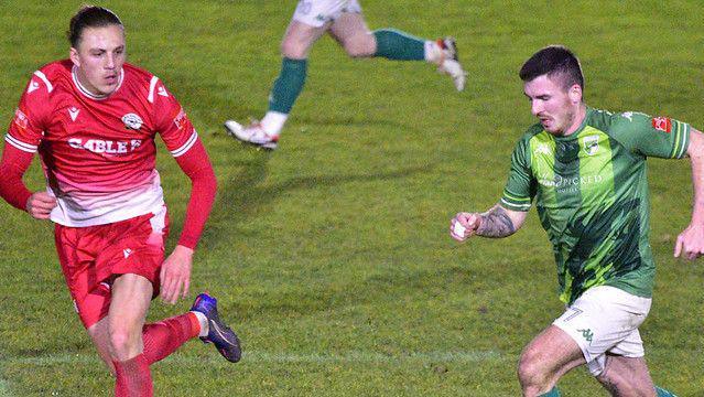 Guernsey FC player running past a Horndean player