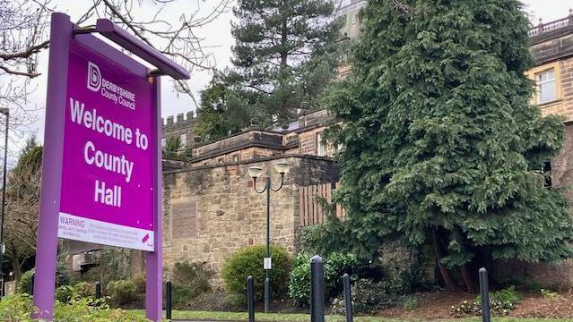 Derbyshire County Hall - a sign and tree can be seen outside a building 