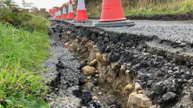 The damaged landslip-hit road, with parts crumbled away