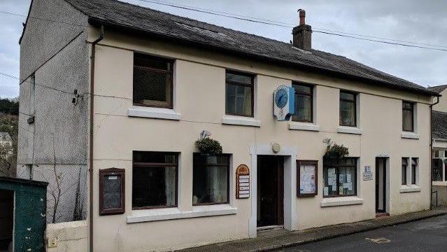 The exterior of the Garff Commissioners office, it is a rundown cream building.