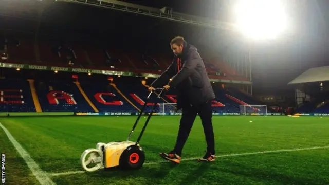 Ground staff prepare the pitch prior to kick-off