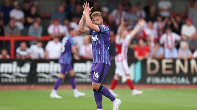 Matty Godden applauds fans in his purple and blue striped Charlton Athletic kit after the side's win over Cheltenham Town in the EFL Cup