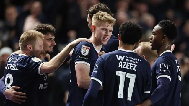 Millwall players in a huddle around Josh Coburn after he scored the winning goal against Derby