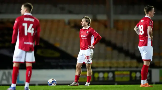 Sam Bell (centre) stands with his hands on his hips and Tomi Horvat (left) stands nearby and Emil Riis (right) with his hands on his hips looking to the right