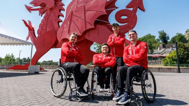 Wales men's 3x3 wheelchair basketball team Alex Wilson, Ben Johnson-Rolfe, Dan May, Will Bishop in front of a Welsh dragon