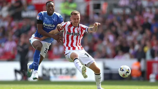 Ebou Adams is held off the ball by Stoke's Ben Wilmot