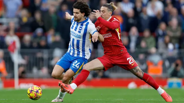 Kostas Tsimikas tackles a Brighton player