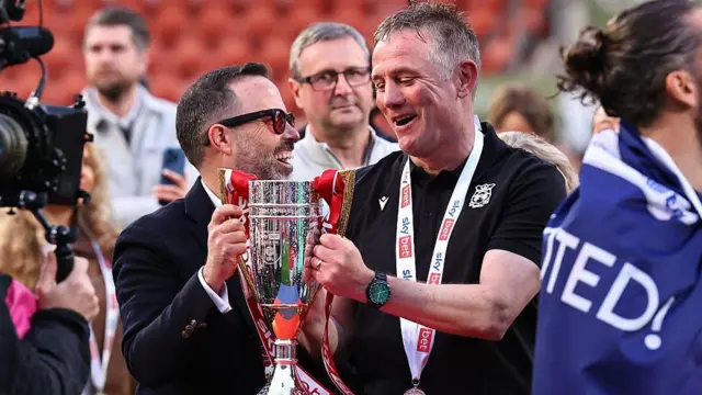 Wrexham manager Phil Parkinson (right) celebrates securing promotion from League One with club CEO Michael Williamson (left)