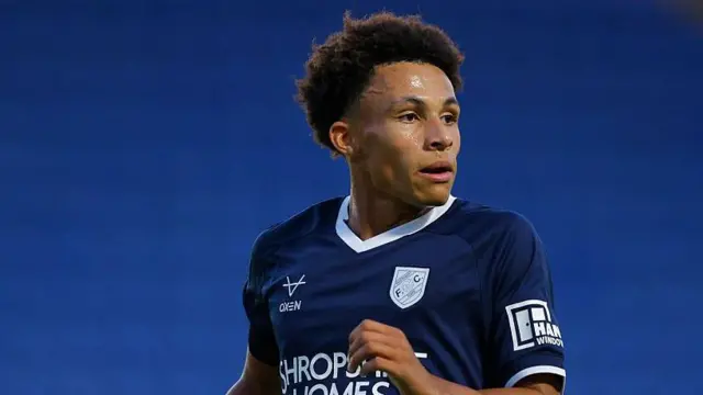 Will Gray in action for Shrewsbury Town in a pre-season friendly. He is wearing a navy blue away shirt