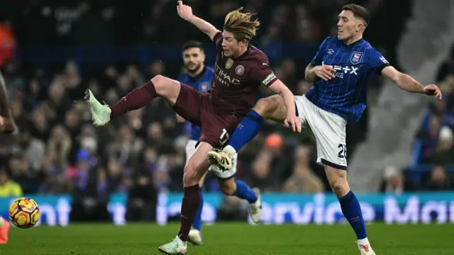 Kevin De Bruyne and Dara O'Shea challenge for the ball