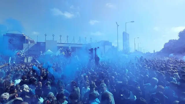 Everton fans consumed in blue flares outside the ground 