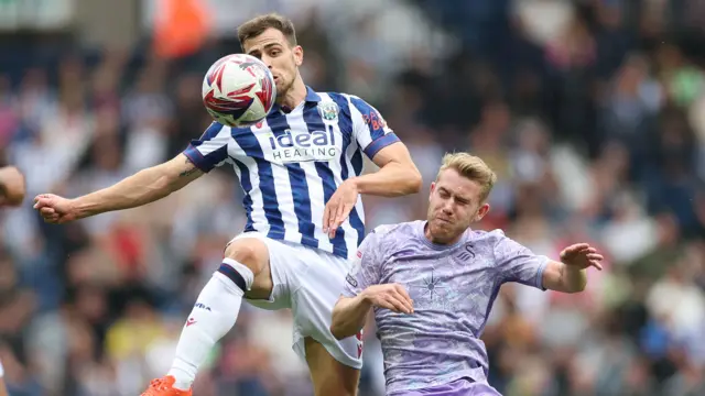 West Bromwich Albion's attacking midfielder Jayson Molumby (L) challenges Swansea City's attacking midfielder Ollie Cooper