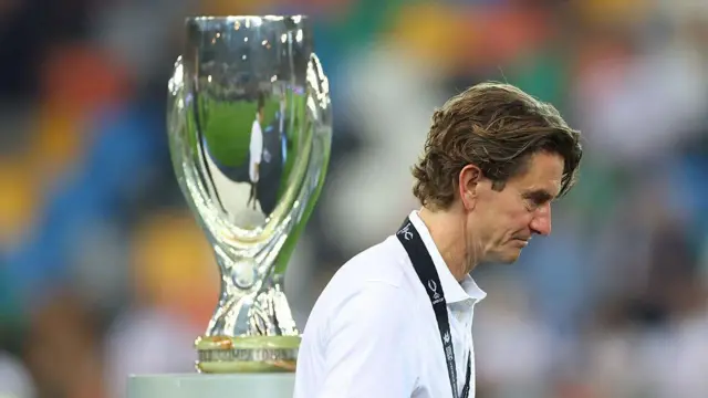 Thomas Frank walks past the Trophy