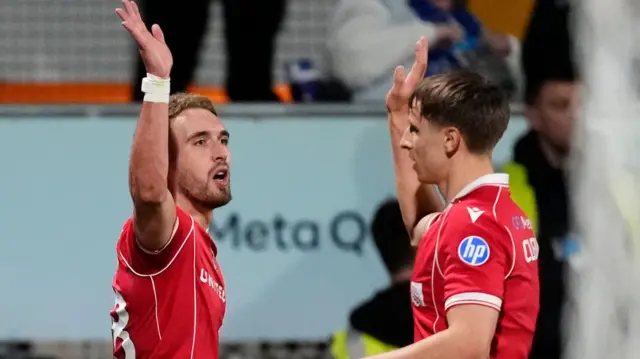 Wrexham striker Sam Smith (left) celebrates with defender Max Cleworth (right)