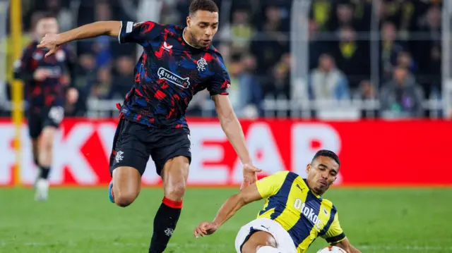 Rangers' Cyriel Dessers (L) and Fenerbahce's Alexander Djiku in action