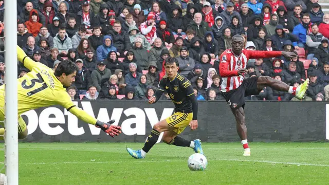 Brian Brobbey has a shot. Lisandro Martinez tries to block and Senne Lammens dives. The ball is going wide of goal.