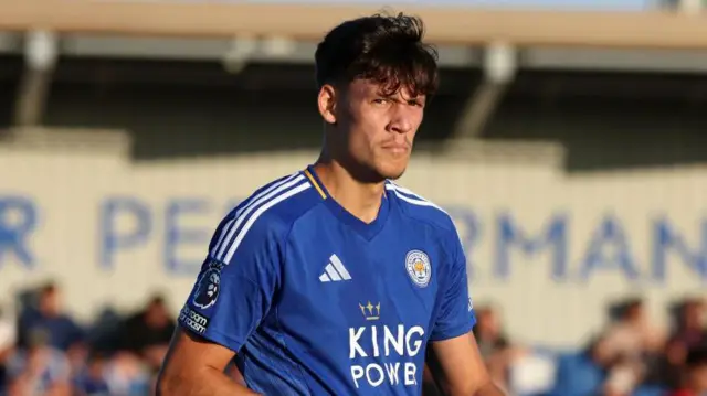 Chris Popov standing on a pitch wearing a Leicester City shirt