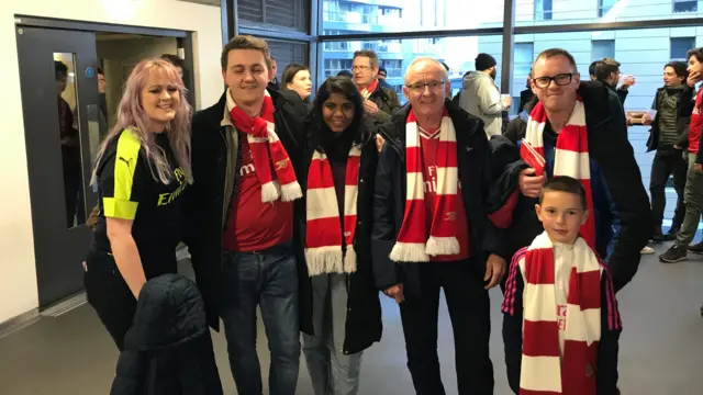 An image of a middle-aged man and his family, including his three children, his daughter-in-law and his grandson, all dressed in Arsenal scarves