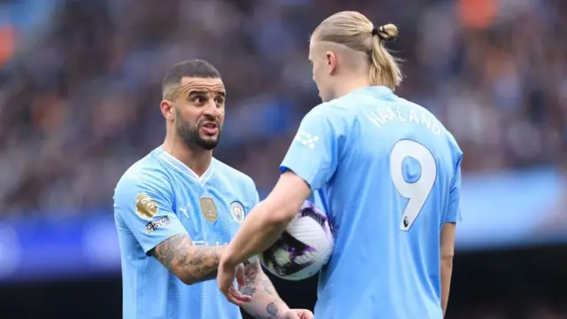 Kyle Walker of Manchester City (L) speaks to Erling Haaland