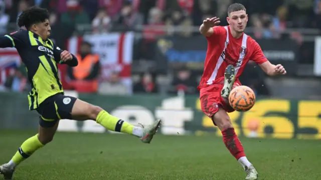 Jamie Donley (R) passes the ball during the FA Cup tie with Manchester City