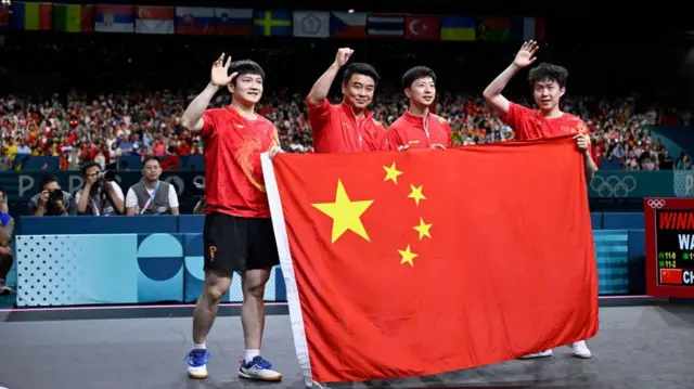 China's Fan Zhendong (L), Wang Chuqin (R) and Ma Long (2nd R) celebrate after defending their Olympic title in Paris