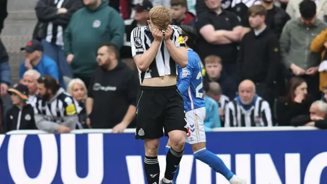 Lewis Hall of Newcastle United shows dejection