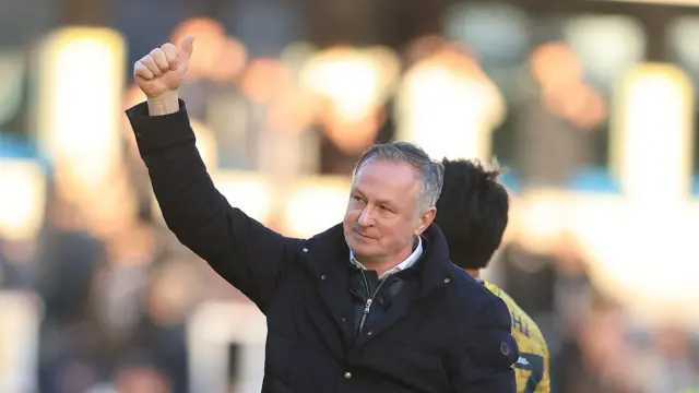 Michael O'Neill raises his arm and gives a thumbs up with his right hand to Blackburn fans at the end of their win at Millwall